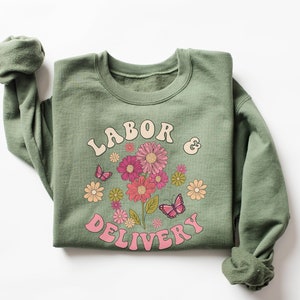 Sage green crewneck sweatshirt with pink floral and butterfly “Labor Delivery” graphic