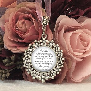 Round flower bouquet charm pendant with floral border and engraved message, on a ribbon loop