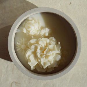 Concrete soy wax pot candle with 3D cream flower bouquet visible on top