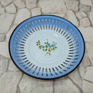 Vintage enamel colander with blue rim and floral pattern center perforated bowl