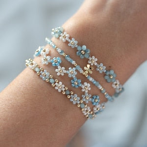 Gold-tone beaded flower bracelet set with light blue blossoms on fine chain