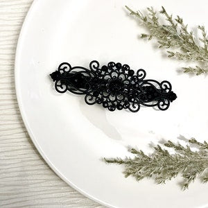 Black ornate hair comb with floral filigree design, decorative barrette clip