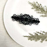 Black ornate hair comb with floral filigree design, decorative barrette clip