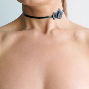 Black leather choker necklace with small flower charm on adjustable strap