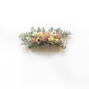 Floral dried-flower hair comb with pastel yellow, pink, and blue blooms.