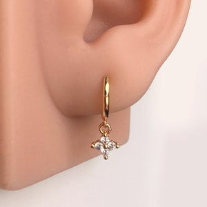 Gold-tone huggie hoop earrings with dangling crystal flower charms