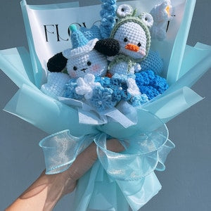 Handmade crochet flower bouquet with light blue ribbon and crochet blooms