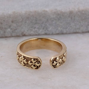 Adjustable brass flower-design knuckle ring with two scalloped filigree bands