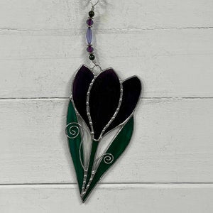 Stained glass flower suncatcher with dark purple and green petal heart shape, hanging bead.