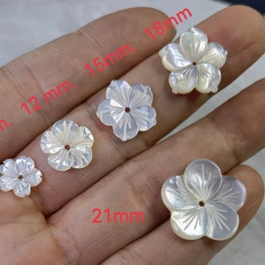 White mother-of-pearl flower beads with carved petals and center hole