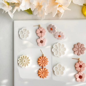 Flower-shaped polymer clay cutter set with white, pink, and orange floral cutters