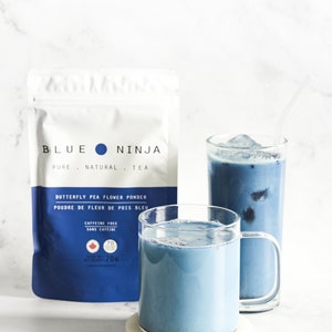 Blue Ninja butterfly pea flower powder sachet with glass mug of blue drink