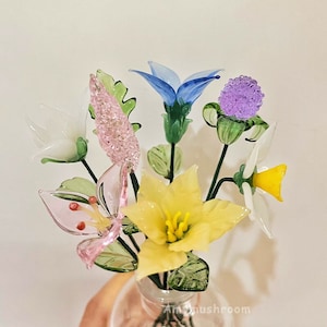 Glass flower figurine bouquet with yellow blooms, blue tulip petals, and pink butterflies
