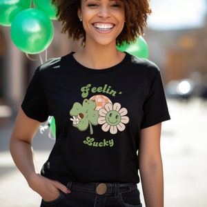 Black unisex short-sleeve jersey T-shirt with green shamrock and clover graphic