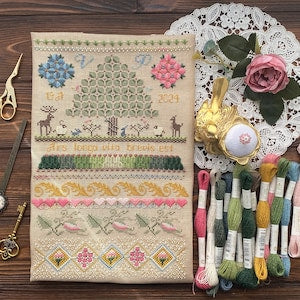 Cross-stitch sampler pattern chart with pastel blue, pink, and yellow motifs and borders