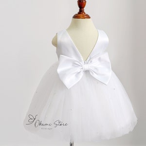 Girls white tulle dress with large satin bow at neckline, layered skirt