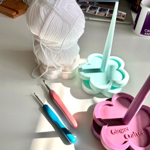 Flower-shaped yarn holder with mint and pink arms, for crochet and knitting yarn