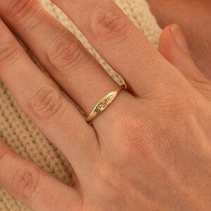 Silver band ring with small gold birth-flower charm, slim stacking style
