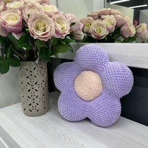 Crochet flower pillow in purple with a cream center