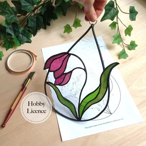 Stained glass flower suncatcher pattern sheet with purple-pink petals and green leaves