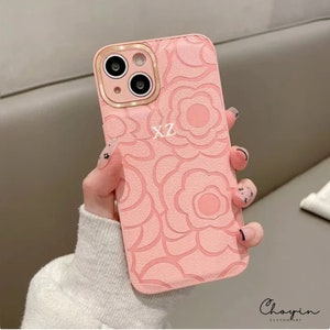 Pink floral leather phone case with embossed pattern and cutout for camera and buttons
