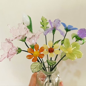 Colorful glass flower figurine bouquet with pink, orange, yellow, green, and purple blooms.