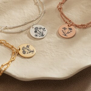 Layered birthflower charm bracelets with round botanical pendants on silver and rose chains