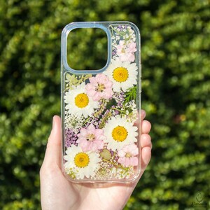 Pressed flower phone case with pink floral design and yellow daisies, clear cover