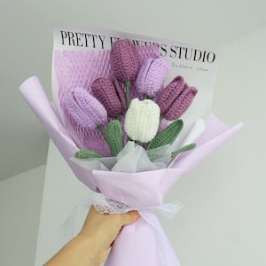 Crochet tulip bouquet with purple flowers and white centers, wrapped in lilac paper.