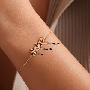 Gold-tone birth flower bracelet with engraved month charms: February, March, May