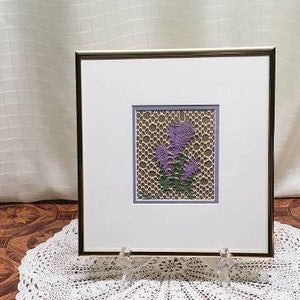 Framed bobbin lace floral wall art with purple and green flower motif