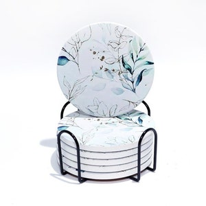 Set of four ceramic drink coasters with minimalist blue-and-white botanical flower design.