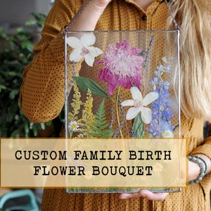 Birth flower pressed flower arrangement in clear display with custom bouquet label