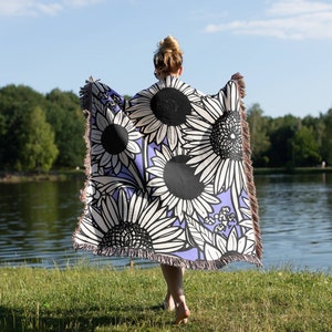Woven throw blanket with black, white, and blue groovy flower pattern