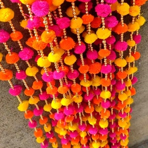Multicolor pom-pom tassel garland with hanging strings for festive backdrop decor