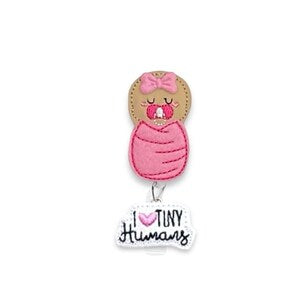 Pink newborn badge reel with baby graphic and "Tiny Humans" text