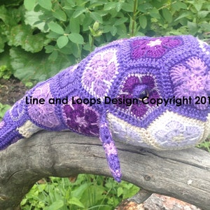 Hand-crocheted whale plush in purple and cream with textured stitch details