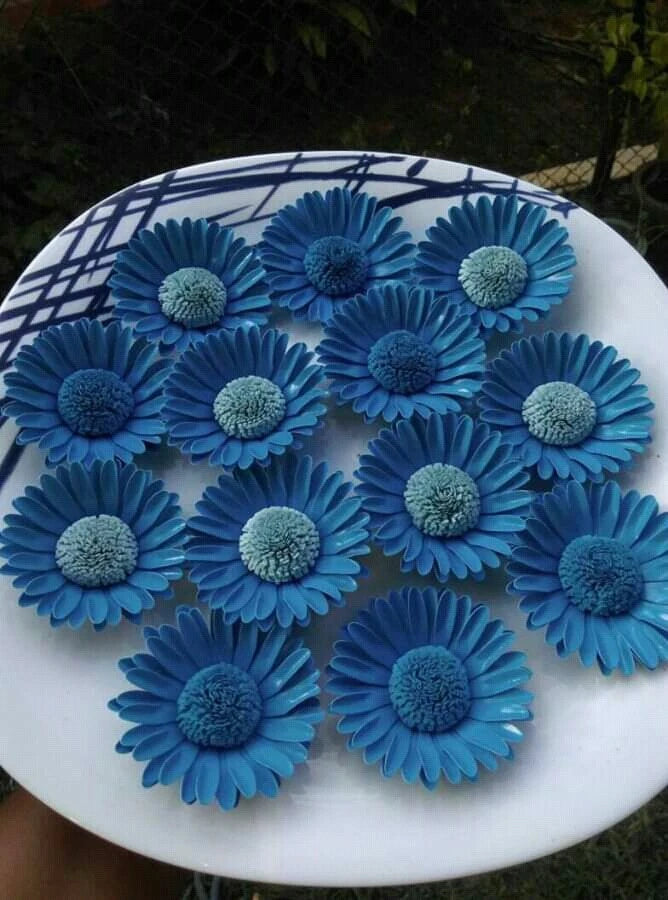 Round wall decor with blue artificial flowers on a white circular base