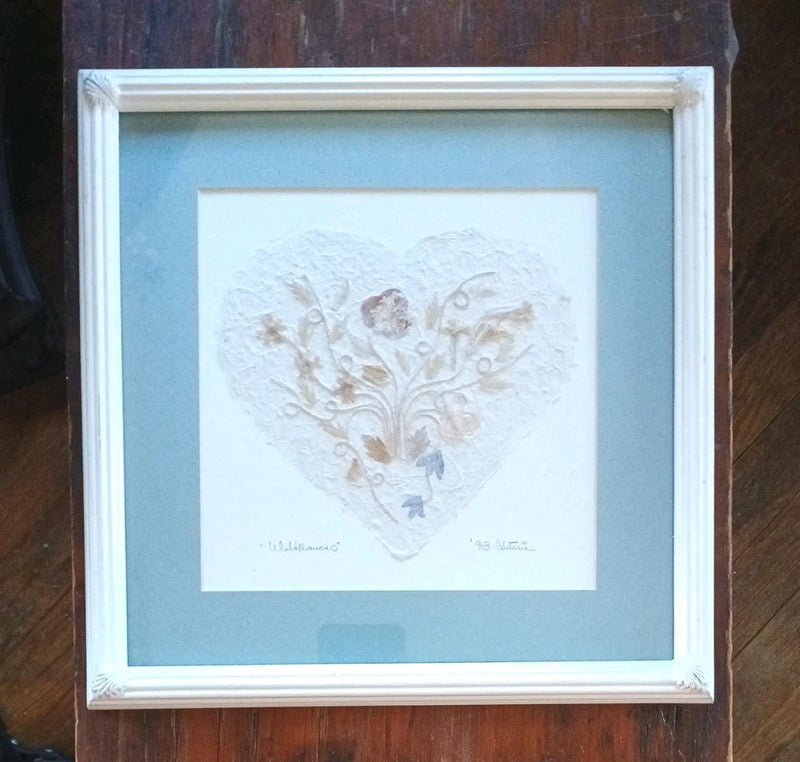 Framed pressed wildflower art with heart-shaped dried flowers and leaves, signed