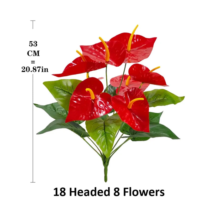 Artificial red flamingo flowers with bright yellow centers and lush green leaves