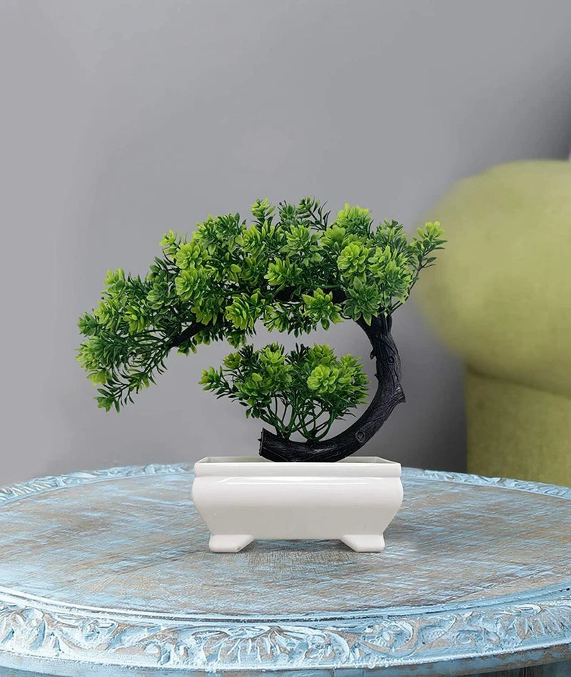 Artificial green bonsai tree in a white rectangular pot