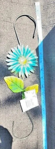 Metal garden hanger with blue sunflower-style flower and green leaves