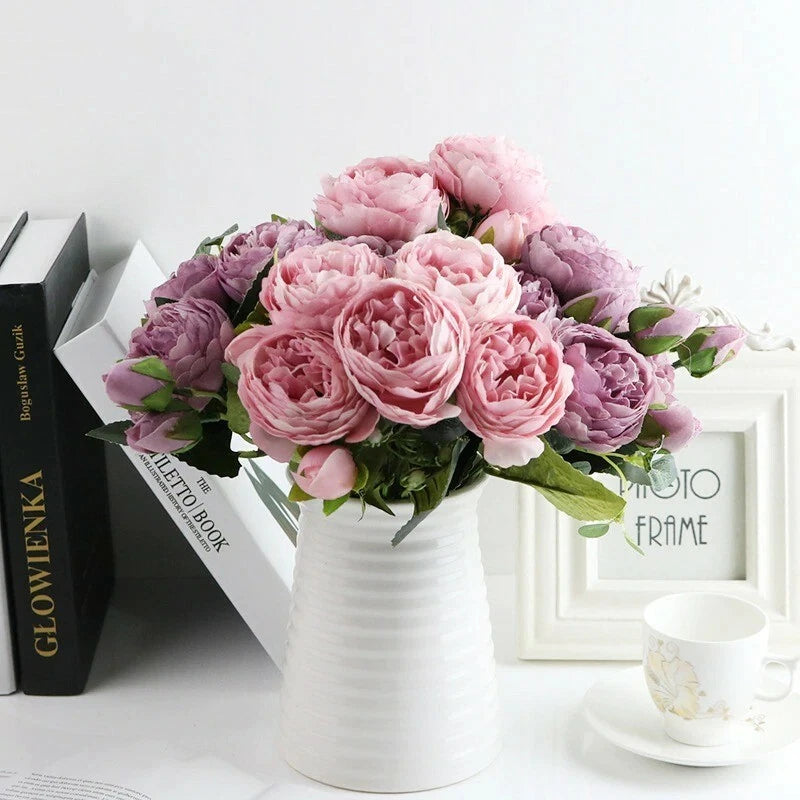 Artificial peony flower bouquet with pink and purple blooms in a white vase