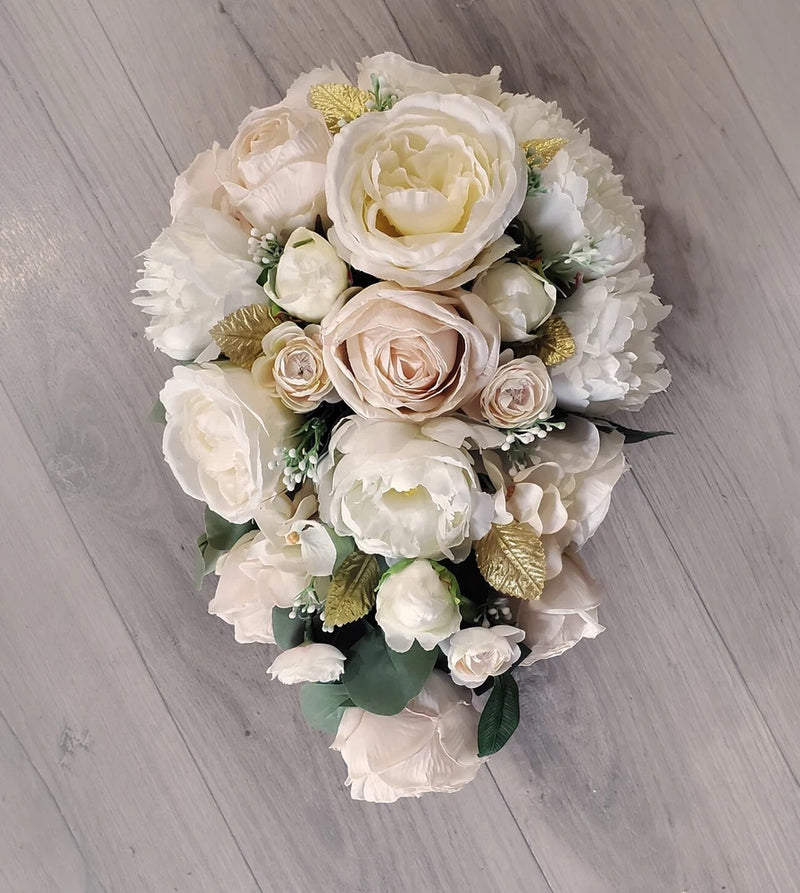 Ivory faux rose bridal bouquet with cascading petals, gold leaf accents, and green leaves