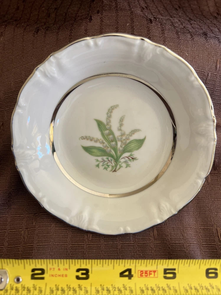 Vintage dessert bowl with white glaze, gold rim, and green floral pattern