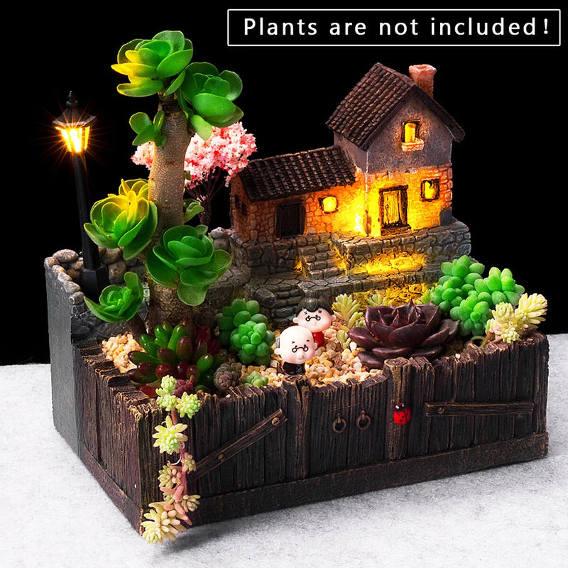 Desktop landscape succulent planter with miniature glowing house and faux plants.