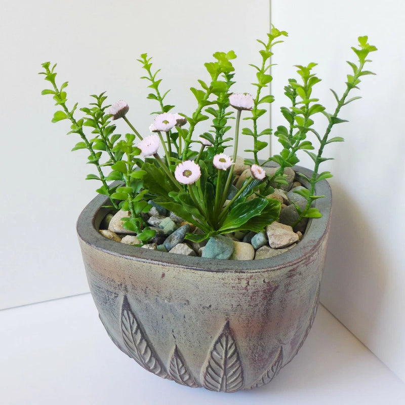 Artificial succulent grass plant with purple-and-white flower heads in a gray embossed pot