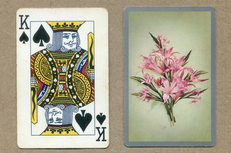 King of Spades playing card with K♠ face and pink lilies floral back