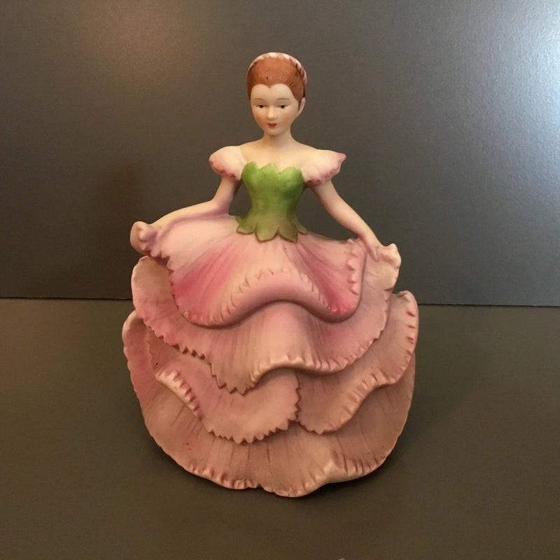 Lady carnation figurine in green bodice and pink ruffled dress, round base