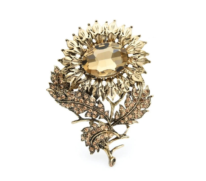 Gold-tone sunflower brooch with round rhinestone center and petal crystals